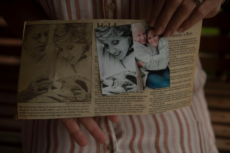 Ashley Helton Rutledge holds the old newspaper clippings about her and her grandparents at the time of her birth and a photograph of her hugging her grandmother, Donna Helton, at Bill Helton's home in Lawrenceburg, Tenn., Friday, July 14, 2023.