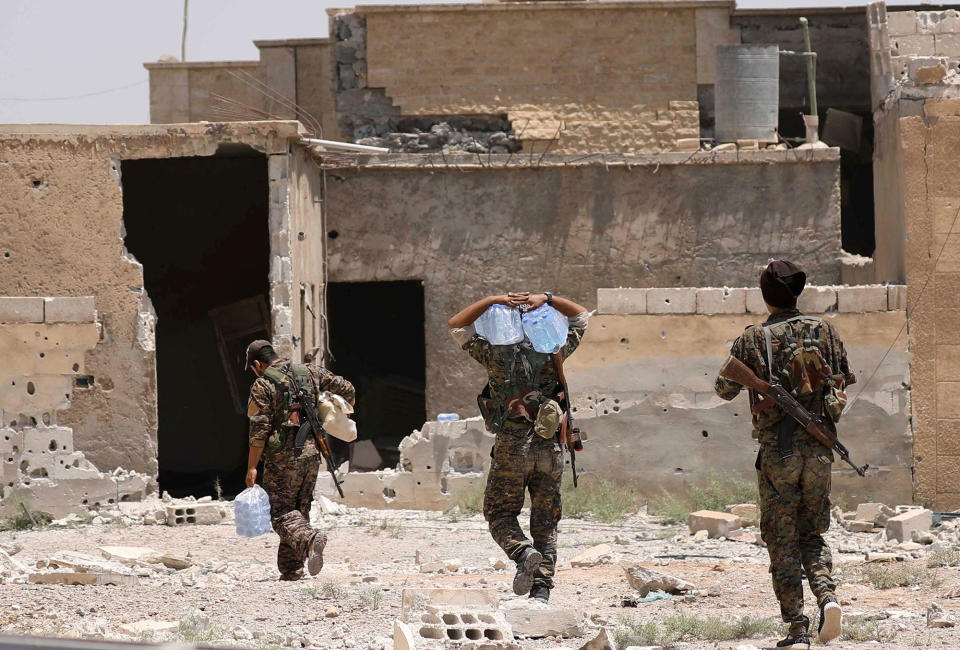 <p>Syrian Democratic Forces (SDF) fighters carry water as they walk in al-Sabahia district, west of Raqqa, Syria June 11, 2017. (Photo: Rodi Said/Reuters) </p>