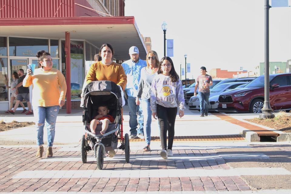 Visitors cross the street in downtown Plainview on April 8.