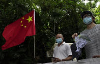 Pro-China supporters displays a picture of U.S. President Donald Trump during a protest against the U.S. sanctions outside the U.S. Consulate in Hong Kong Saturday, Aug. 8, 2020. The U.S. on Friday imposed sanctions on Hong Kong officials, including the pro-China leader of the government, accusing them of cooperating with Beijing's effort to undermine autonomy and crack down on freedom in the former British colony. (AP Photo/Vincent Yu)