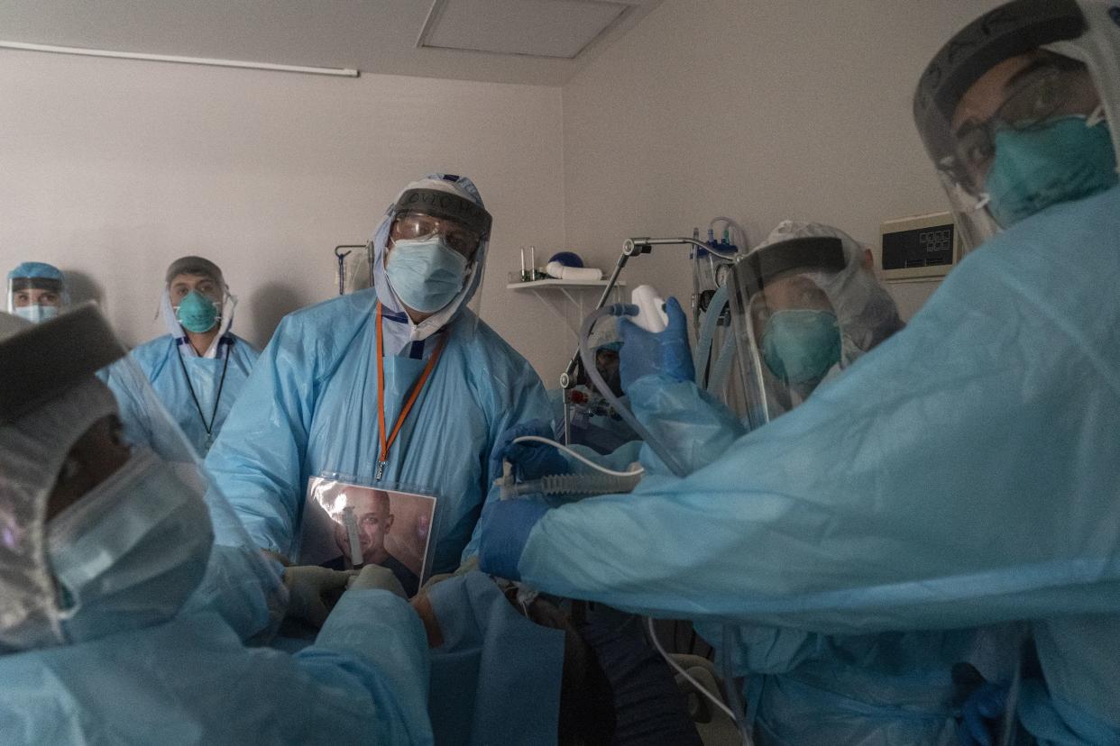 Medical staff members monitor an endoscope as they perform percutaneous tracheostomy procedure on a patient in the COVID-19 intensive care unit (ICU) during Thanksgiving at the United Memorial Medical Center on Nov. 26, 2020 in Houston, Texas.