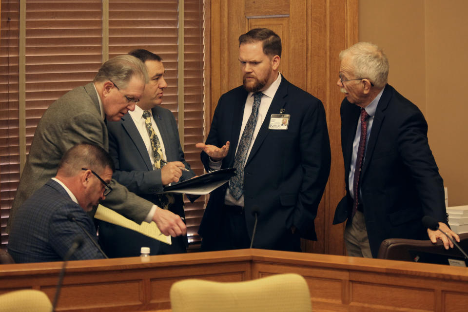 From left to right, Kansas state Sens. Rick Kloos, R-Topeka, and Mike Thompson, R-Shawnee, and Rep. Pat Proctor, R-Leavenworth, confer with Jason Long and Mike Heim of the Legislature's legal staff following negotiations between the House and Senate over elections legislation, Monday, April 1, 2024, at the Statehouse in Topeka, Kan. Republicans have revived a plan to stop giving voters an extra three days after Election Day to return mail ballots. (AP Photo/John Hanna)