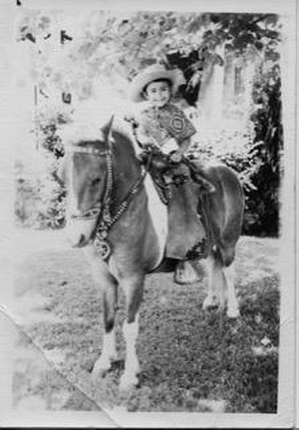 Rosemary Galdiano, 7, sits on a pony in front of her house on Drew Street, 1962. She recalls her neighborhood was riddled with gang violence in the 1970s.