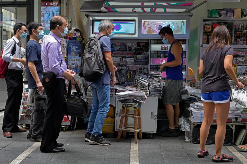 People queue up to buy the Apple Daily newspaper in Hong Kong (AP)
