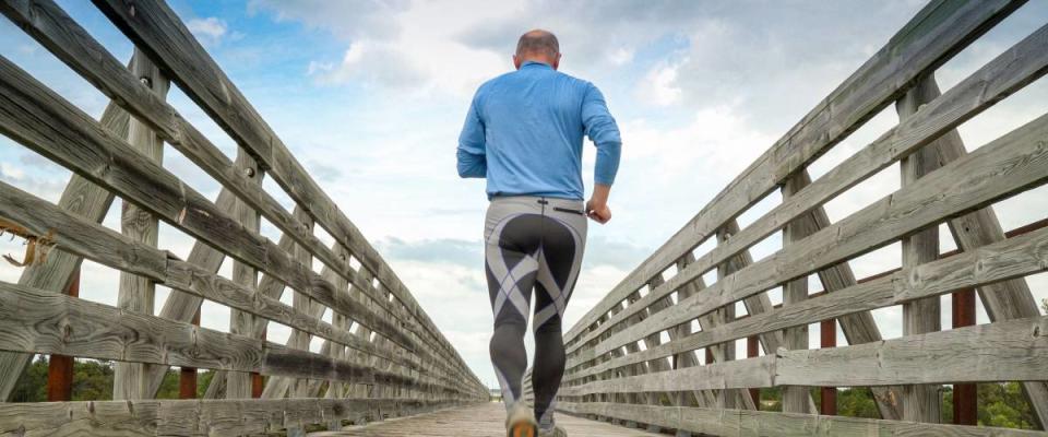 senior man is running on a long trestle over Long Pine Creek -  recreational Cowboy Trail in northern Nebraska