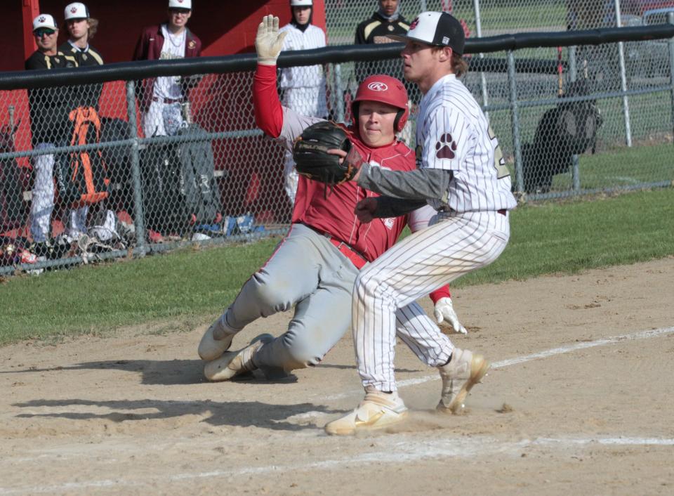 Alex Brossman of Constantine slides safely into home plate to score a run for the Falcons on Wednesday.