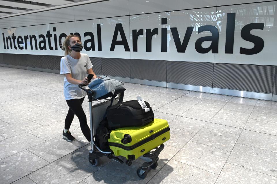 Passengers wearing a face mask or covering due to the COVID-19 pandemic, arrive at Heathrow airport, west London, on July 10, 2020. - The British government on Friday revealed the first exemptions from its coronavirus quarantine, with arrivals from Germany, France, Spain and Italy no longer required to self-isolate from July 10. Since June 8, it has required all overseas arrivals -- including UK residents -- to self-quarantine to avoid the risk of importing new cases from abroad. (Photo by DANIEL LEAL-OLIVAS / AFP) (Photo by DANIEL LEAL-OLIVAS/AFP via Getty Images)