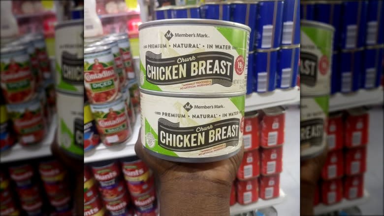 Hand holding canned chicken breast