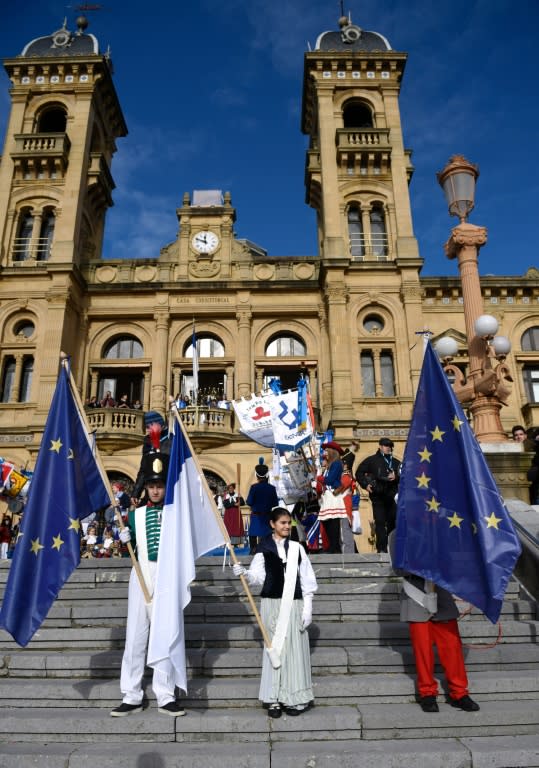 Children hold European Union flags and the city standard during the "Tamborrada" (dum parade) in the northern Spanish Basque city of San Sebastian on January 20, 2016 marking San Sebastian day