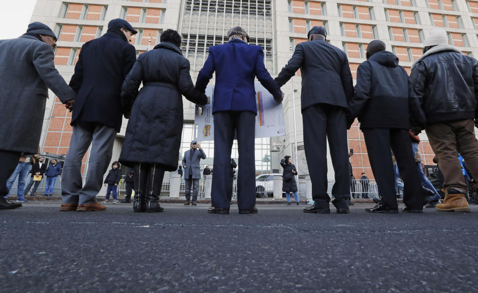 Community and religious leaders gather and join hands to protest and pray outside the Metropolitan Detention Center in New York on Sunday, Feb. 3, 2019. Some demonstrators protesting the lack of heat and electricity at the federal detention center in New York City attempted to enter the facility Sunday, and witnesses said guards drove them back with pushes, shoves and pepper spray. (AP Photo/Kathy Willens)