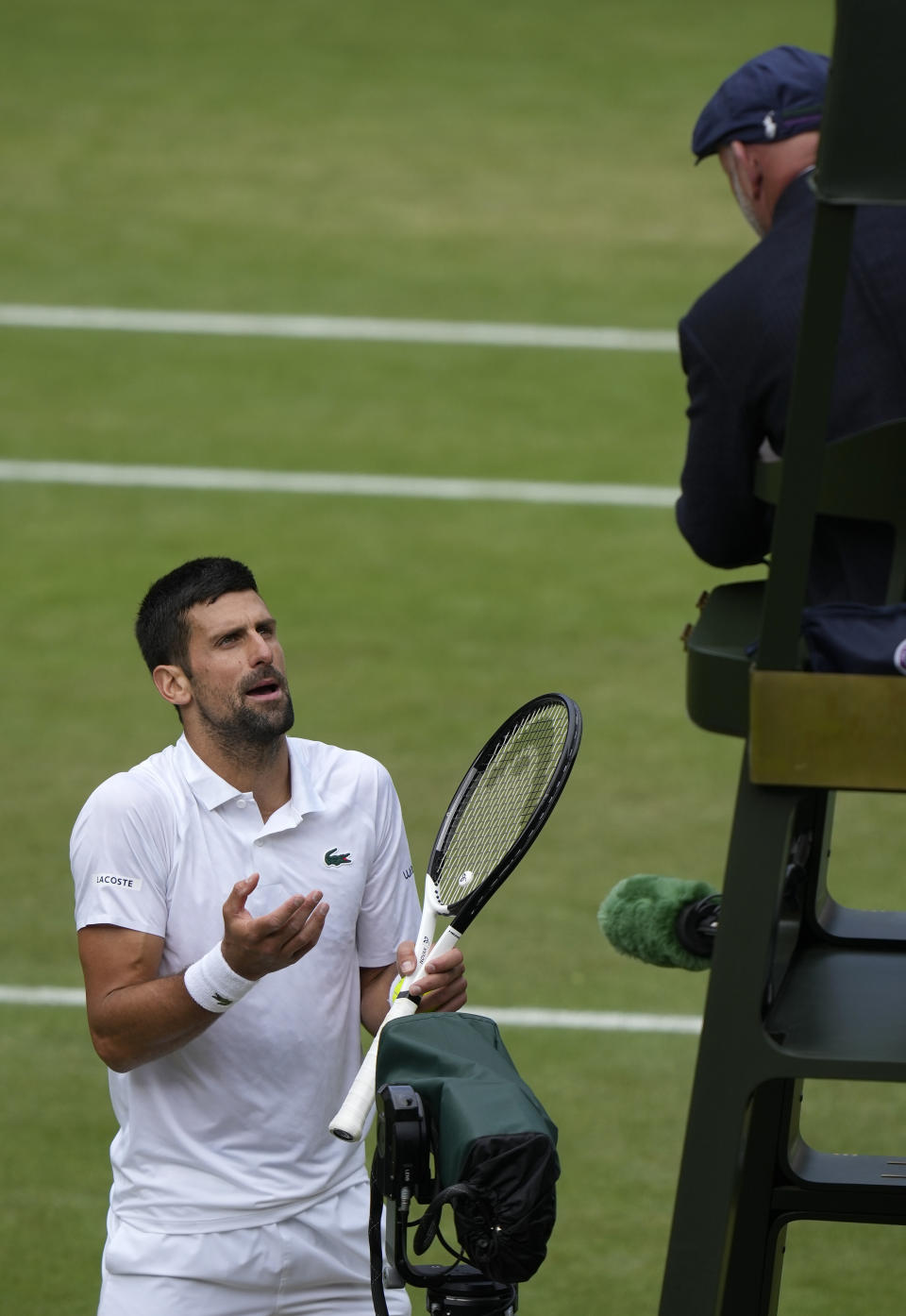 Serbia's Novak Djokovic questions a call by umpire Fergus Murphy as he plays Spain's Carlos Alcaraz in the final of the men's singles on day fourteen of the Wimbledon tennis championships in London, Sunday, July 16, 2023. (AP Photo/Alastair Grant)