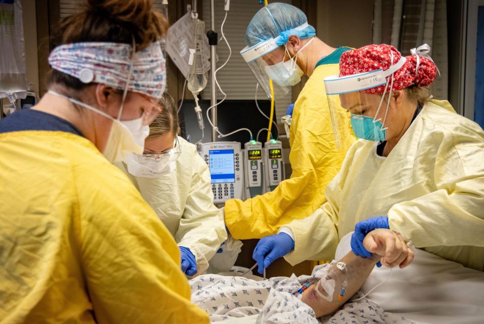 Nurses, respiratory therapists and patient care techs gather to prone a COVID-19 patient in the ICU at Mary Greeley Medical Center in Ames on Thursday, Jan. 6, 2022.