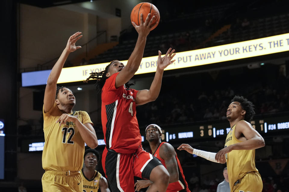 Georgia guard Silas Demary Jr. (4) shoots the ball past Vanderbilt guard Evan Taylor (12) and guard Tyrin Lawrence, right, during the second half of an NCAA college basketball game Wednesday, Feb. 21, 2024, in Nashville, Tenn. Georgia won 76-64. (AP Photo/George Walker IV)