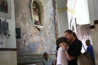 <p>Orisnela Solano hugs her daughter, Laura Goenaga as they attend a church service at the Parroquia Nuestra Senora de la Asuncion church September 24, 2017 in Aibonito, Puerto Rico. Puerto Rico experienced widespread damage after Hurricane Maria, a category 4 hurricane, passed through. (Photo: Joe Raedle/Getty Images) </p>