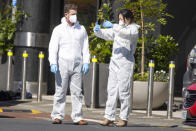 Police forensic staff stand outside a supermarket in Auckland, New Zealand, Saturday, Sept. 4, 2021. New Zealand authorities say they shot and killed a violent extremist, Friday, Sept. 3 after he entered the supermarket and stabbed and injured six shoppers. Prime Minister Jacinda Ardern described Friday's incident as a terror attack. (AP Photo/Brett Phibbs)