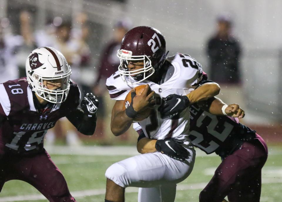 Concord’s Jerah Wright runs the ball Caravel’s Brandon Simendinger (22) and Richie Massey (18) try to bring him down during the Buccaneers’ 44-6 win over the Raiders at Bob Peoples Stadium, Friday, Sept. 30, 2022.