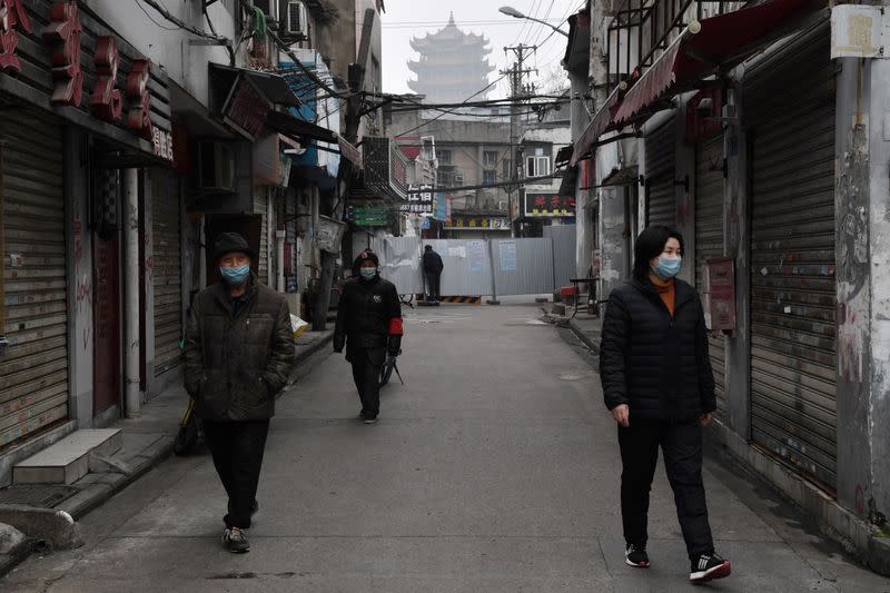 People wearing masks are seen in an alley near the Yellow Crane Tower in Wuhan, the epicentre of the novel coronavirus outbreak