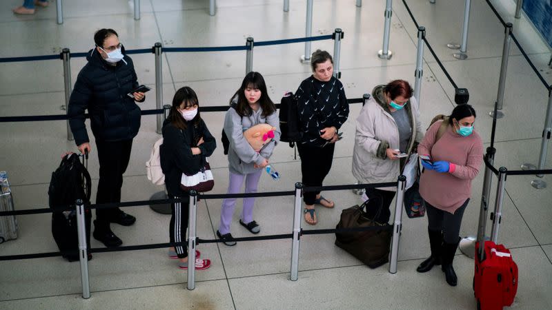 FILE PHOTO: People wait in line to reach TSA immigration process at the John F. Kennedy International Airport in New York