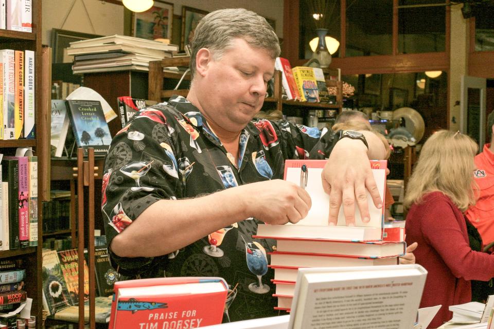 Author Tim Dorsey busily signing books at Muse Books, DeLand in 2011.