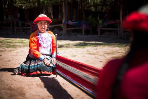 A Peruvian woman weaving in the village of Ccaccaccollo - Credit: Getty