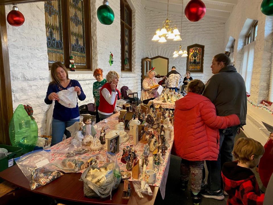 Volunteers from Southside Christian Church offer nativity sets as gifts for children going through the recent “Deck the Halls” event at the ARC Empowerment Center.