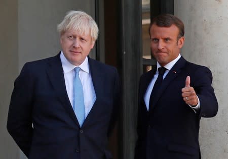 French President Emmanuel Macron reacts next to British Prime Minister Boris Johnson after a joint statement before a meeting on Brexit at the Elysee Palace in Paris