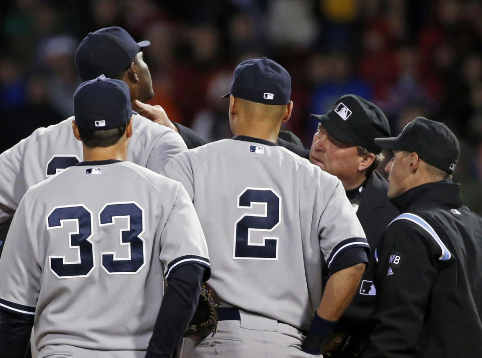 Home plate umpire Gerry Davis touches the neck of New York Yankees starting pitcher Michael Pineda in the second inning of the Yankees' baseball game against the Boston Red Sox at Fenway Park in Boston, Wednesday, April 23, 2014. Pineda was ejected after umpires found with a foreign substance on his neck. (AP Photo/Elise Amendola)