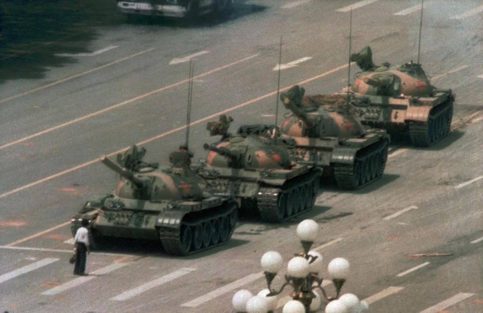 FILE - In this June 5, 1989 file photo, a Chinese man stands alone to block a line of tanks heading east on Beijing's Changan Blvd. in Tiananmen Square. The man, calling for an end to the recent violence and bloodshed against pro-democracy demonstrators, was pulled away by bystanders, and the tanks continued on their way. Over seven weeks in 1989, student-led pro-democracy protests centered on Beijing’s Tiananmen Square became China’s greatest political upheaval since the end of the Cultural Revolution more than a decade earlier.(AP Photo/Jeff Widener, File )