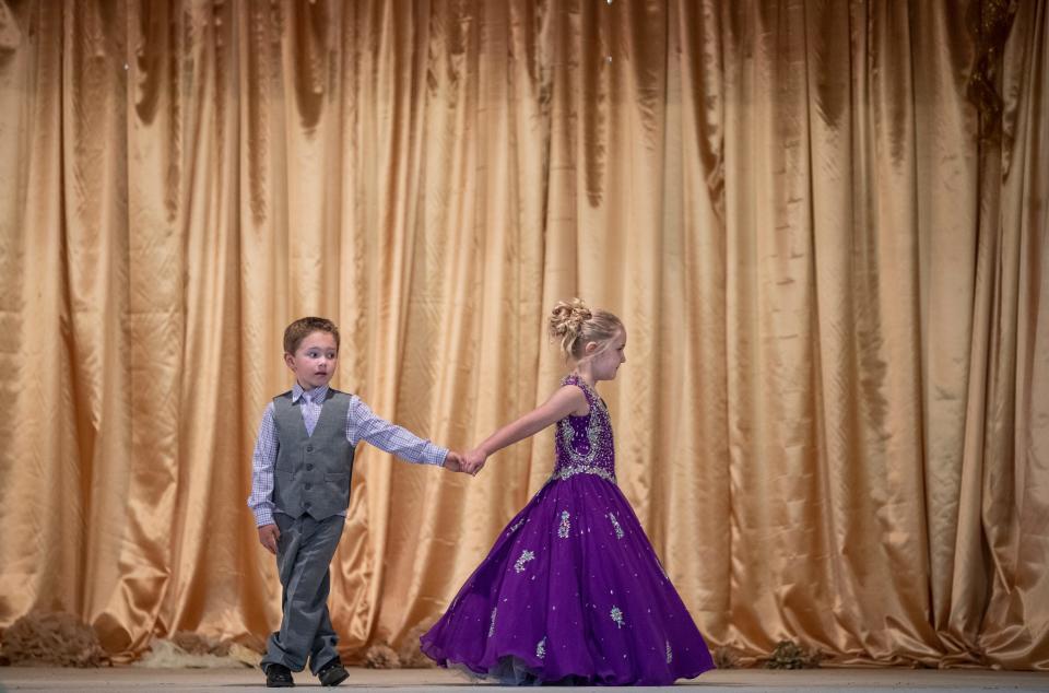 Ruby Craig, 5, leads tSeth Zega, 5, from the stage after being named Little Miss and Mr. Oldham County and the Oldham County Fair. July 30, 2019.