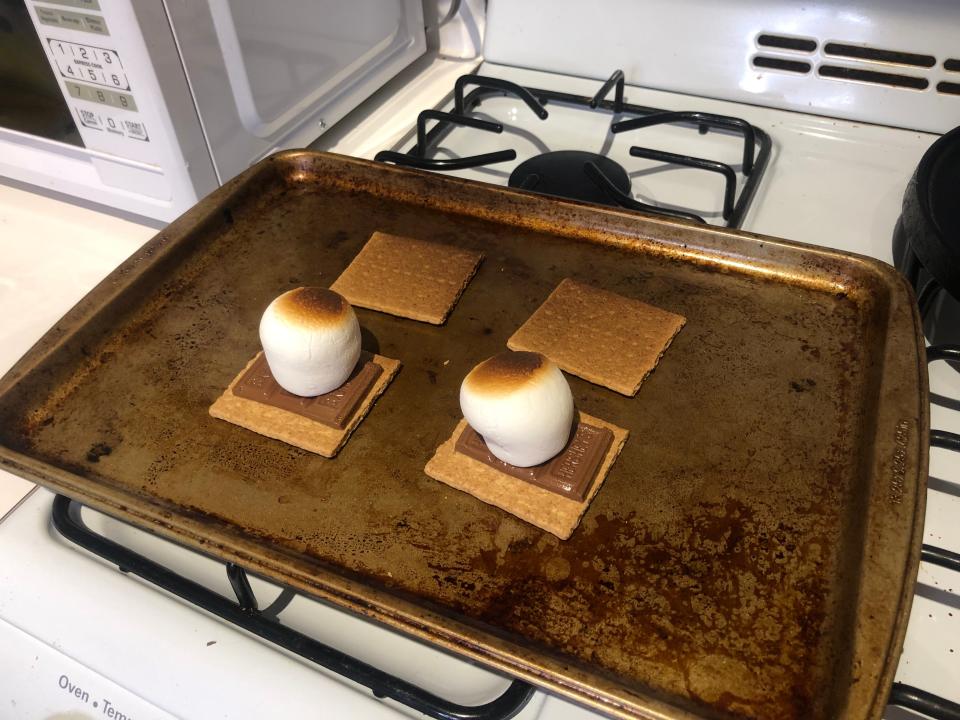 two cooked smores on a sheet pan on a stovetop
