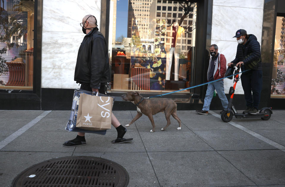 SAN FRANCISCO, CALIFORNIA - APRIL 15: A pedestrian carries a shopping bag as he walks through the Union Square shopping district on April 15, 2021 in San Francisco, California. According to a report by the U.S. Commerce Department, retail sales surged 9.8 percent in March as Americans started to spend $1,400 government stimulus checks. (Photo by Justin Sullivan/Getty Images)