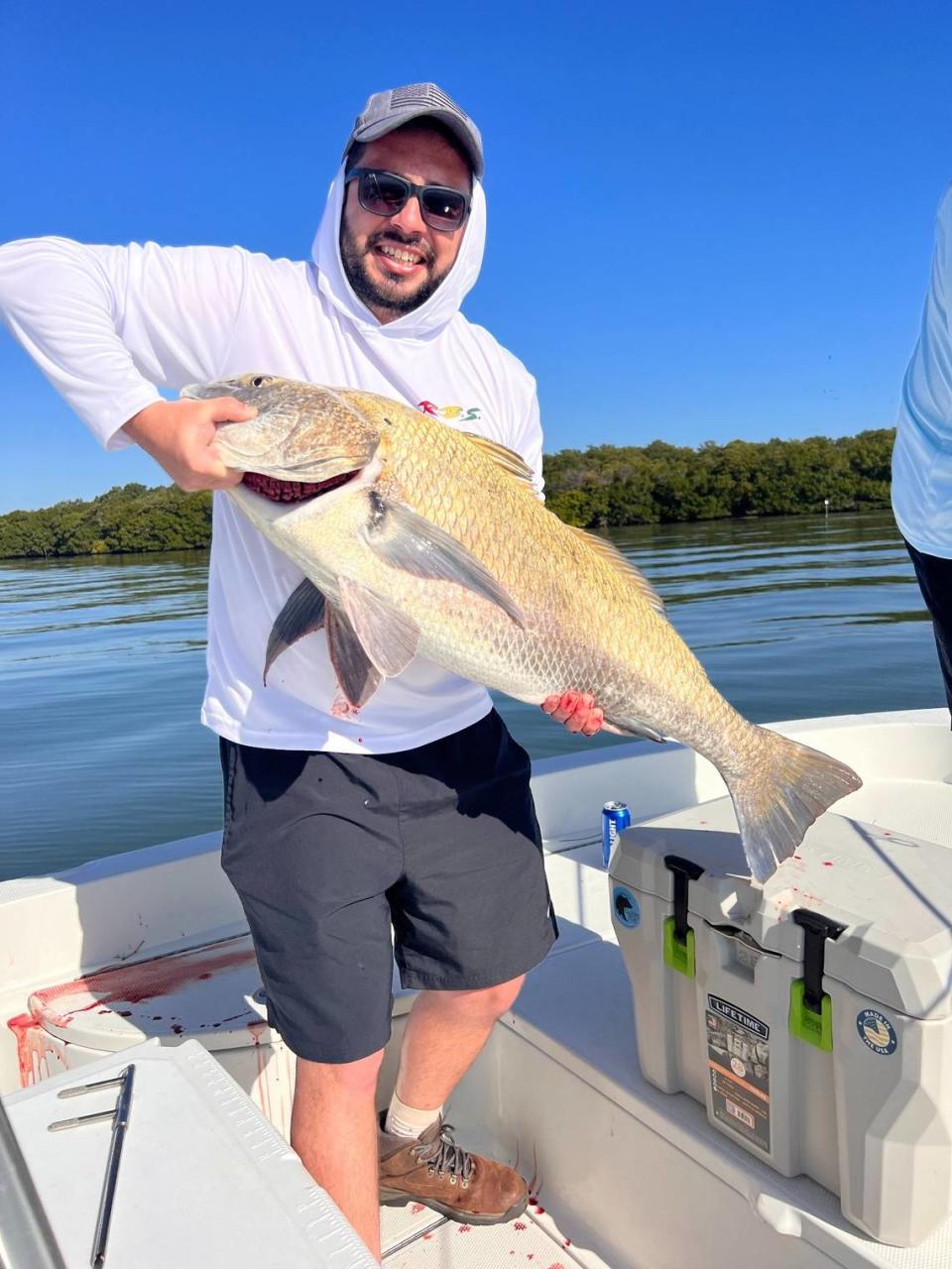 Katchesco Calavetti (right) with black drum caught fishing with Capt. Brett Norris in Tampa Bay.