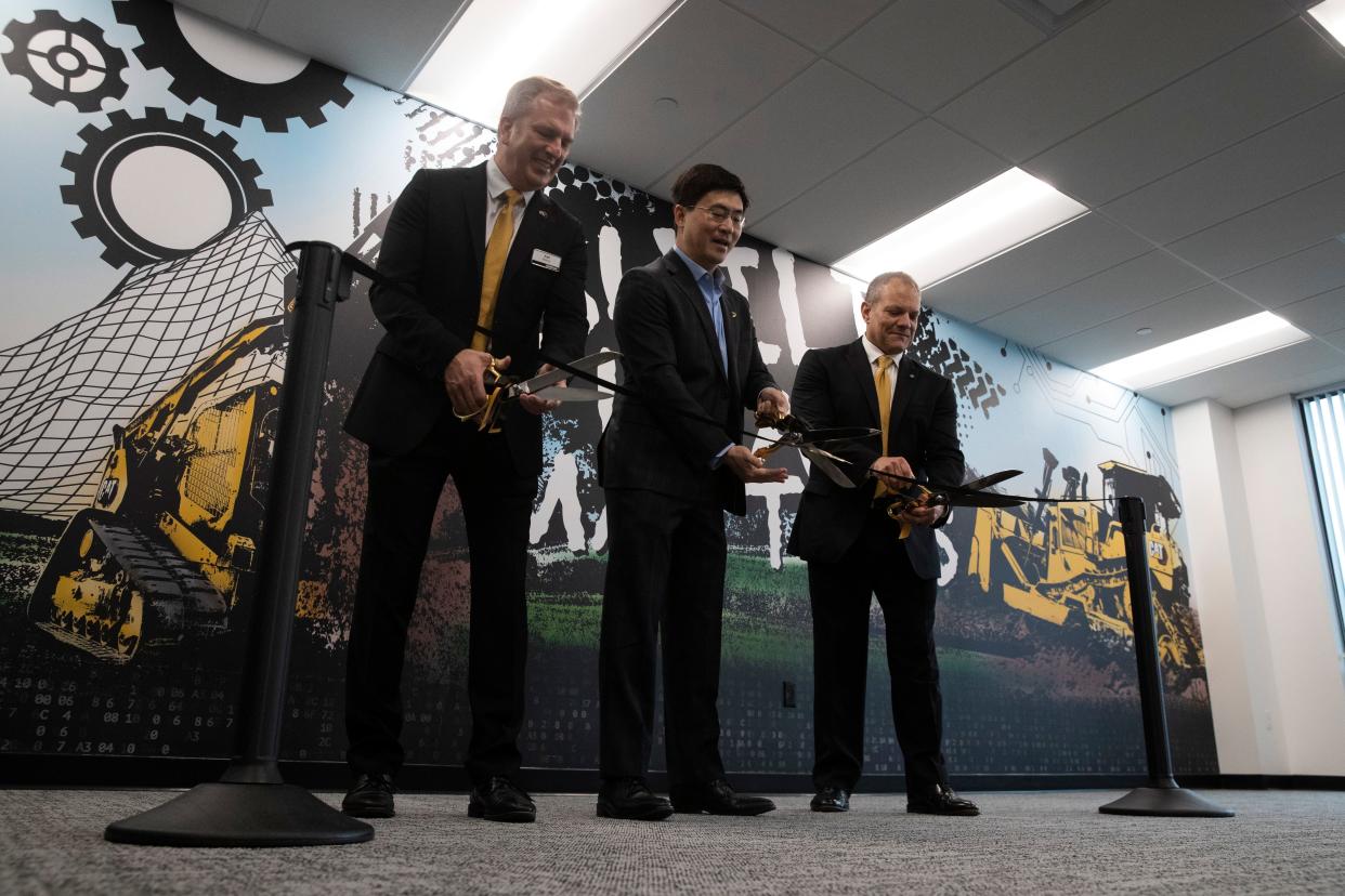 Purdue University President Mung Chiang cuts the ribbon for Caterpillar's new office, Tuesday, April 4, 2023, at the Convergence Center in West Lafayette, Ind.