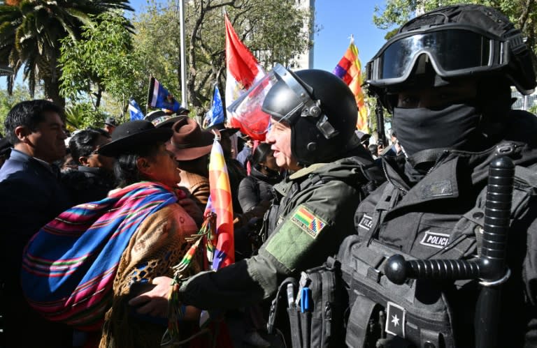 Simpatizantes del expresidente boliviano Evo Morales discuten con agentes antidisturbios frente al Tribunal Supremo Electoral (TSE) durante una reunión con partidos políticos para debatir las elecciones judiciales y primarias en La Paz, el 10 de julio de 2024. (AIZAR RALDES)