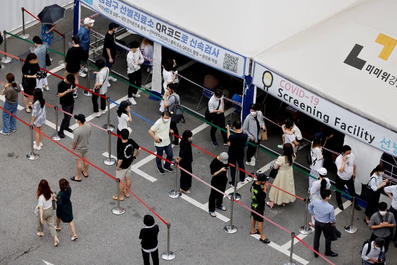 FILE PHOTO: People wait in line for a coronavirus disease (COVID-19) test at a testing site which is temporarily set up at a public health center in Seoul