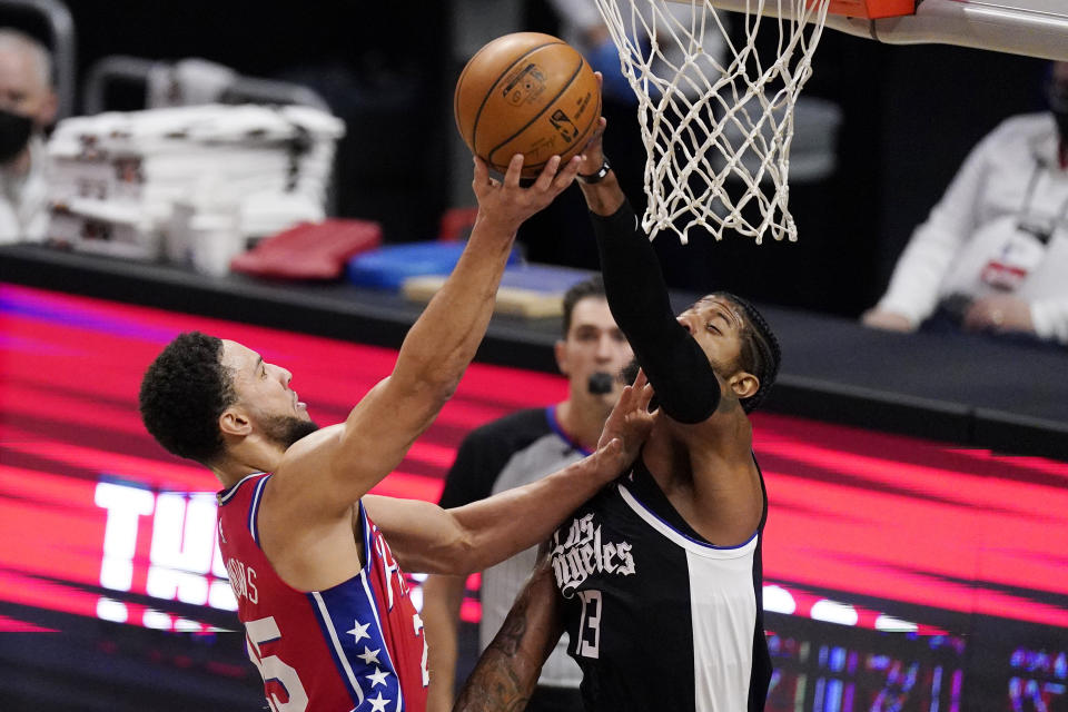 Philadelphia 76ers guard Ben Simmons, left, shoots as Los Angeles Clippers guard Paul George defends during the first half of an NBA basketball game Saturday, March 27, 2021, in Los Angeles. (AP Photo/Mark J. Terrill)