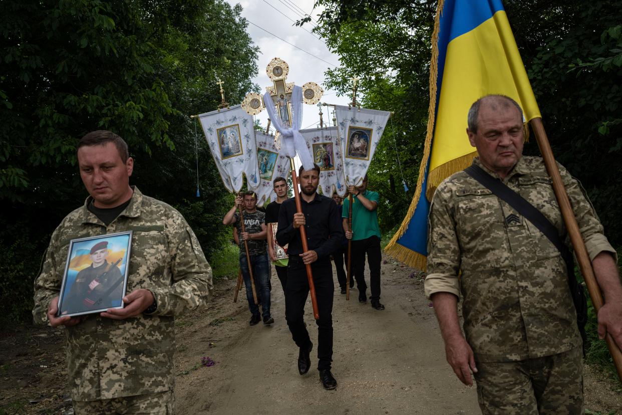 Ukrainian servicemen carry a National flag and a photograph of Ukrainian serviceman Bohdan Kobylianskyi (AP)