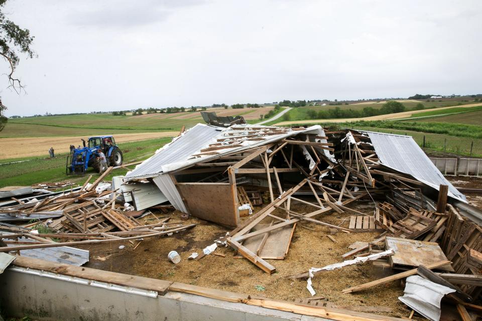 Neighbors help Rick Brenneman clean up his property after a tornado hit his barn near 540th Street SW and Angle Road SW Friday, May 24, 2024 near Frytown, Iowa.