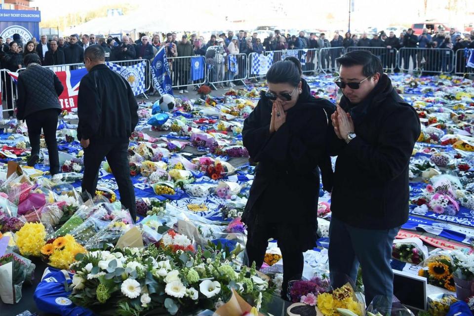 Aiyawatt Srivaddhanaprabha (R) and Aimon Srivaddhanaprabha (L) view flowers and tributes left (AFP/Getty Images)