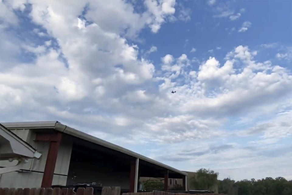 A small airplane circles over Tupelo, Miss., on Saturday, Sept. 3, 2022. Police say the pilot of the small airplane is threatening to crash the aircraft into a Walmart store. The Tupelo Police Department said that the Walmart and a nearby convenience store had been evacuated. (Rachel McWilliams via AP)