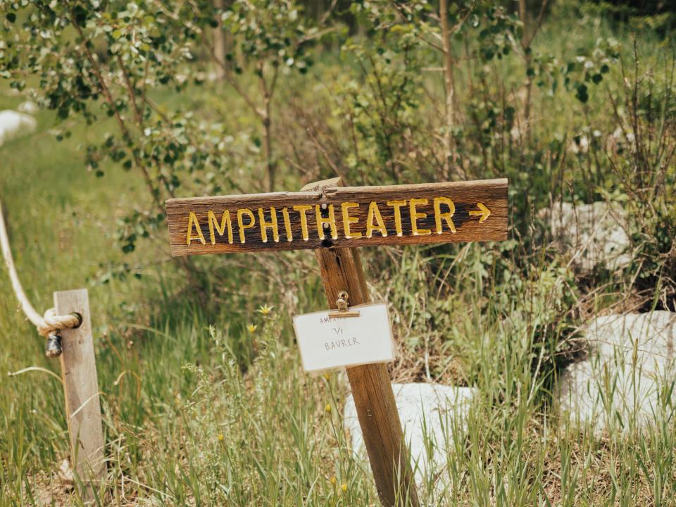 wooden sign that reads amphitheater in yellow letters at maroon bells in colorado