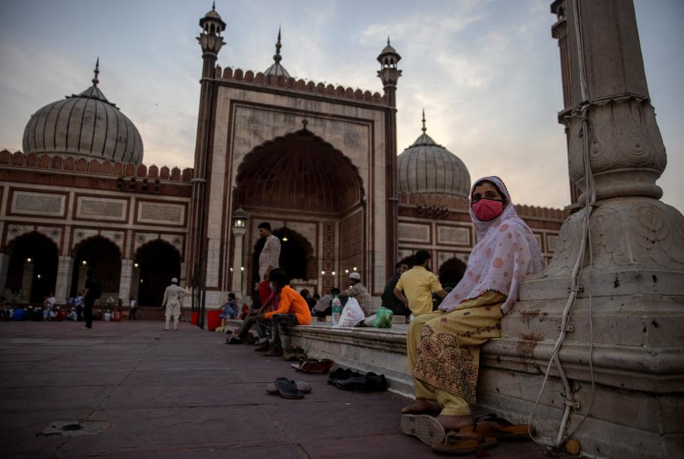 People wait to have their Iftar (breaking fast) meals on the first day of the Muslim fasting month of Ramadan at Jama Masjid in Delhi