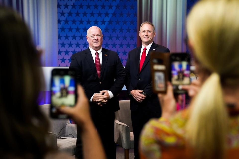 Kevin Thompson, left, and Nicholas Myers, right, take a photo together before a debate for the office of Arizona Corporation Commissioner on Wednesday, June 22, 2022, in Phoenix.