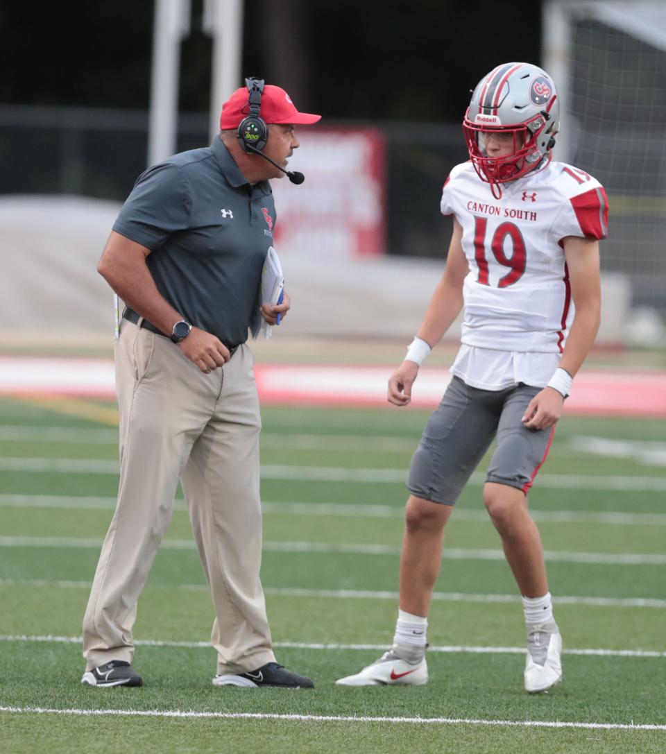 Canton South head coach Matt Dennison talks with sophomore QB Poochie Snyder during their game at Northwest, Friday, Sept. 3, 2021.