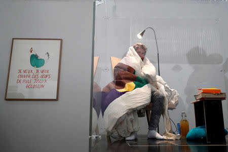 French artist Abraham Poincheval is seen in a vivarium on the first day of his performance in an attempt to incubate chicken eggs, which takes from 21 to 26 days, at the Palais de Tokyo Museum in Paris, France, March 29, 2017. REUTERS/Gonzalo Fuentes TPX IMAGES OF THE DAY