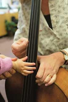 Parents can help their little ones pluck strings and touch the orchestra's different musical tools during Meet the Instruments.