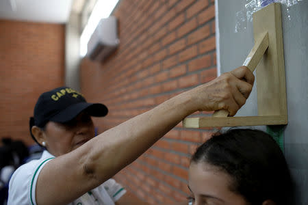 A child gets her height measured during a health program of the NGO "Comparte por una vida" (Share for a life) at La Frontera school in Cucuta, Colombia February 5, 2019. Picture taken February 5, 2019. REUTERS/Marco Bello