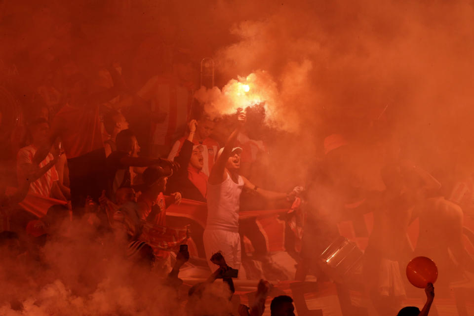A Colombia Junior soccer fan holds up a burning flare as fans get revved before the start of the Copa Sudamericana first leg final match against Brazil's Atletico Paranaense, at the Metropolitano stadium in Barranquilla, Colombia, on Wednesday, Dec. 5, 2018. The match ended in a 1-1 draw. (AP Photo/Fernando Vergara)