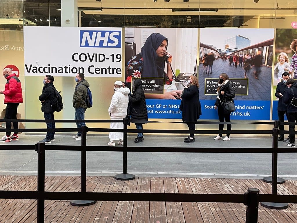 People queue at a Covid-19 vaccination centre at the Westfield in Stratford, east London  (PA )