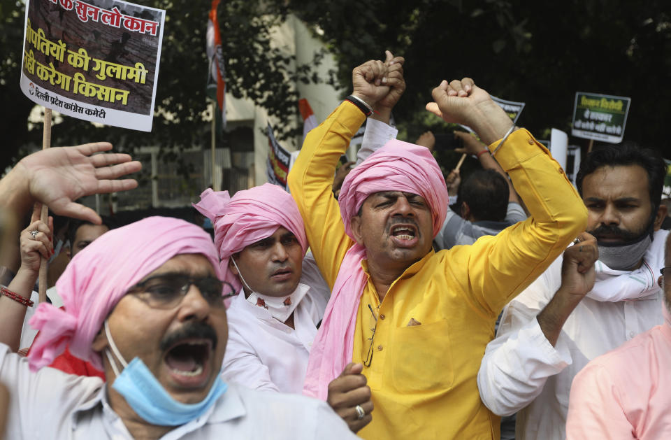 Members of India's opposition Congress party shout anti government slogans during a protest against farm bills in New Delhi, India, Monday, Sept. 21, 2020. Amid an uproar in Parliament, Indian lawmakers on Sunday approved a pair of controversial agriculture bills that the government says will boost growth in the farming sector through private investments. (AP Photo/Manish Swarup)